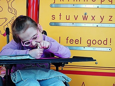 a child sitting in front of the Braille Wall